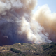 Smoke and flames envelope a ridge as a firefighting helicopter tries to stop the the fire. (EPA/Eugene Garcia)